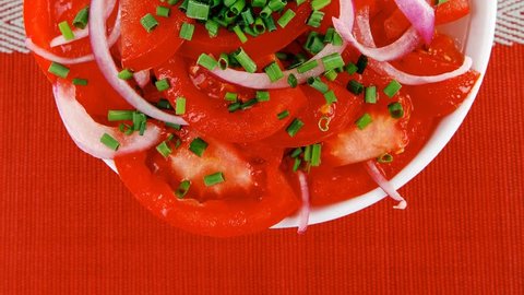 healthy food : fresh tomato salad with onion and chives in white bowl over red cloth