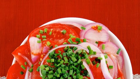 healthy food : fresh tomato salad with onion and chives in white bowl over red cloth