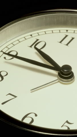 Vertical time lapse video of a clock time passing over a day to night on black background.
