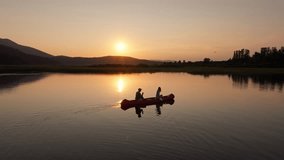 Silhouette couple, male and female, tandem canoeing on a beautiful calm lake in the golden hour, aerial shot. Romance adventure concept. - Powered by Shutterstock - Get 15% off with code: PIKWIZARD15