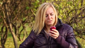 Young blonde woman holds cell phone when boy comes and covers her eyes in park at sunny autumn day - Powered by Shutterstock - Get 15% off with code: PIKWIZARD15