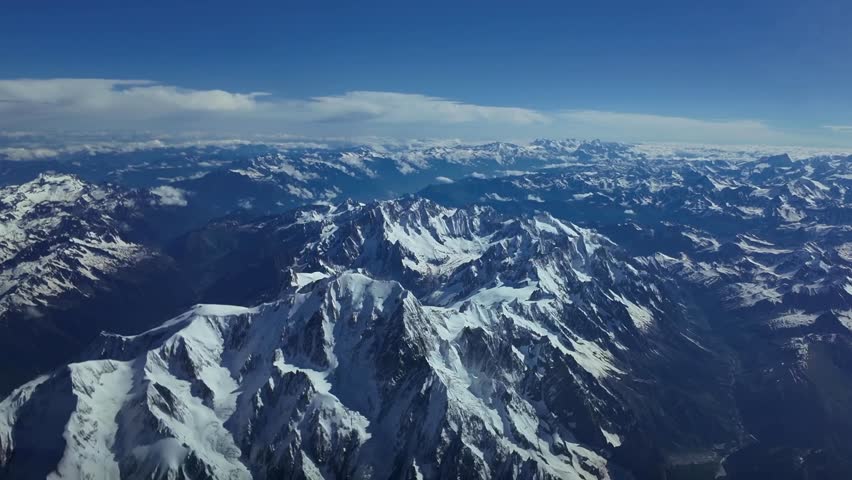 Elevated aerial close-up view of The Mont Blanc snowed summit shot from a jet cockpit overflying the peak at 8000m high. An exclusive pilot perspective. Daylight, 4K 60FPS