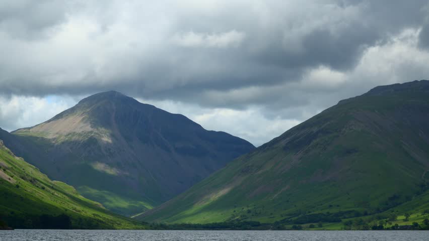 Thick clouds skimming summit of mountain Great Gable as shadows race across the landscape. Timelapse 30x. English Lake District, Wasdale, Cumbria, UK