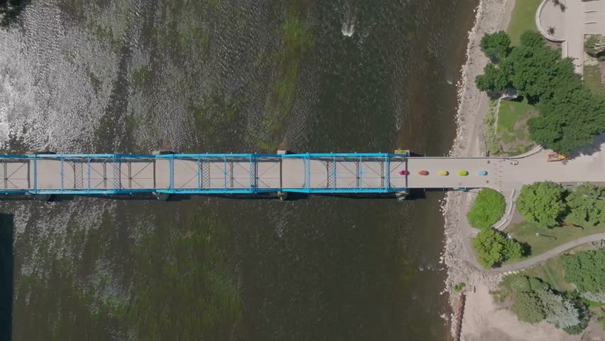 Blue bridge over Grand River in downtown Grand Rapids, Michigan with drone video overhead moving down.