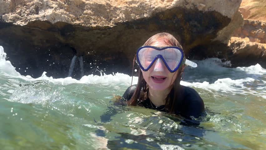 Child girl in a swimming mask explores the underwater world