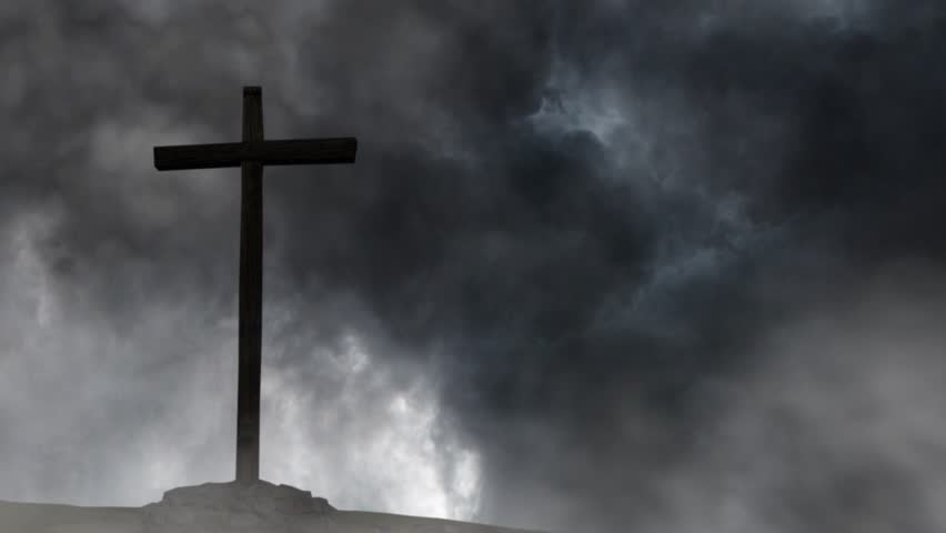 silhouette of a wooden cross against a background of storm and black clouds.