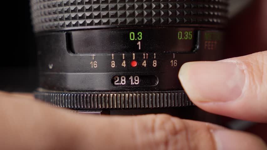 Professional Photographer Adjusting Lens Aperture Stop. Close-up Shot