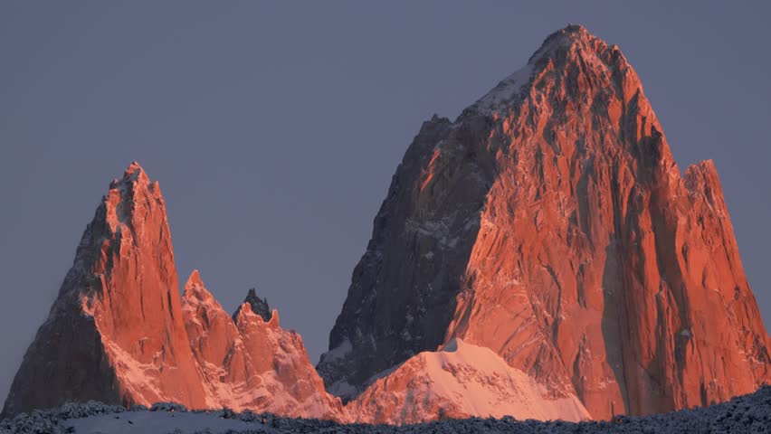 Orange-red morning light illuminates Mount Fitz Roy in Patagonia. Static zoomed-in view