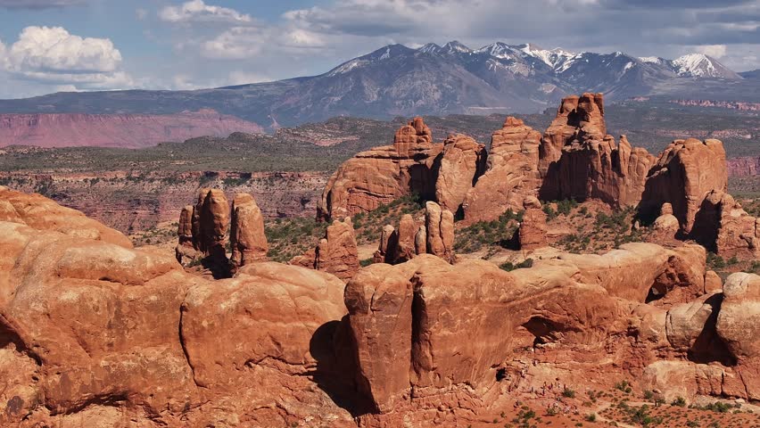 Stunning view of red rock formations in Moab, Utah, with snow-capped mountains in the background. USA