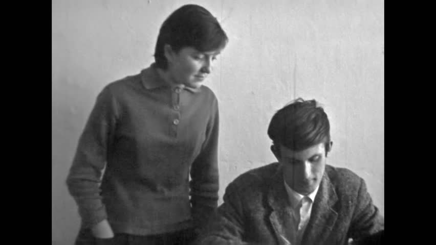 Archive film, woman professor teacher teaching lesson to students in university classroom. Student writing, learning lecture in college indoor. Study at lecture. Vintage black white movie. Retro 1980s