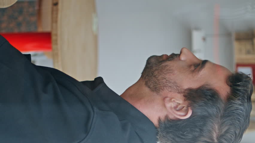 Couple male friends meeting in cozy cafe view through window close up. Two multiethnic guys talking laughing together at friendly gathering. Cheerful men speaking joking in coffee house vertical video