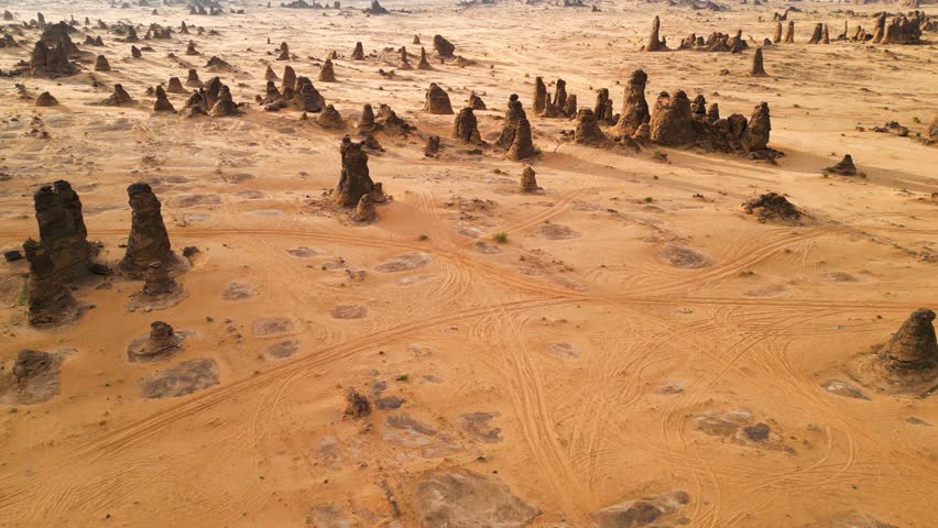 A mesmerizing aerial view of Saudi Arabia’s unique desert landscape showcasing towering rock formations and intricate sand patterns carved by natural forces.