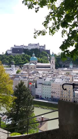 View of Salzburg castle and the old town through the green trees