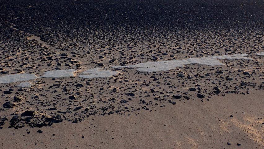 Cracked half-buried in sand European roadside. Damage on public infrastructures due Climate Change
