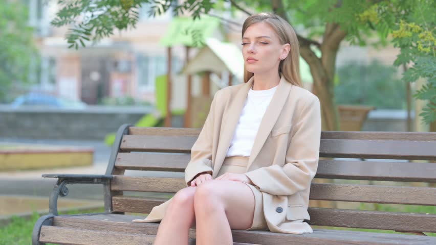 Pensive Businesswoman Sitting Outdoor on Bench