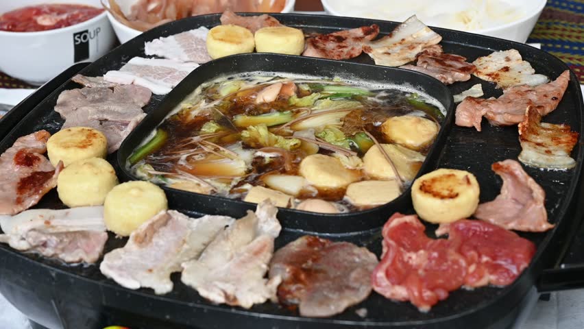 Footage of people enjoying their party with Korean BBQ and Shabu Shabu dinner. Korean BBQ is the popular method of grilling meat right at the dining table.