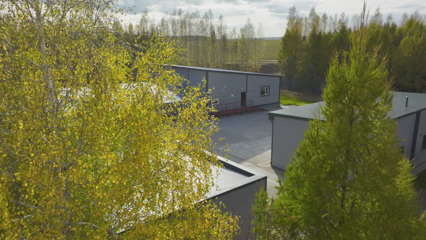 Wastewater processing reservoirs under roof between workshops at treatment plant aerial view. Sewage water purification station at countryside