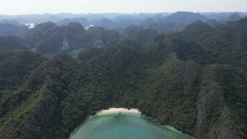 drone shot over private beach amidst limestone cliffs in Cat Ba and Halong Bay in Northern Vietnam