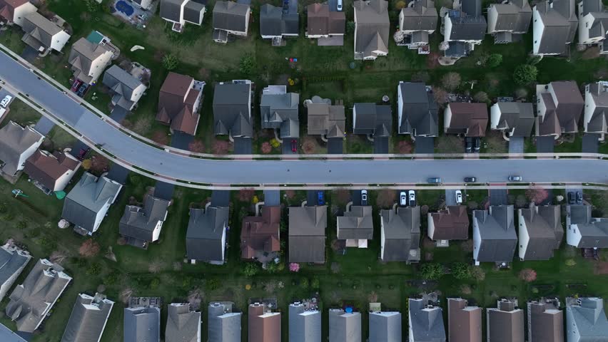 Aerial top down shot of single family homes in suburbia of american town. Dense populated neighborhood at golden Sunset. 