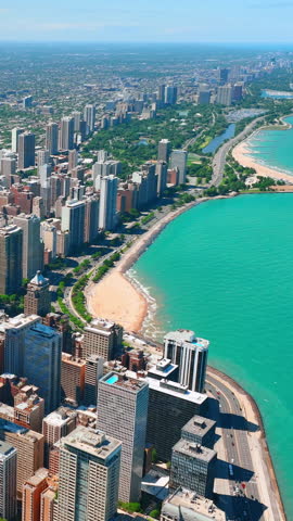 Aerial view of skyscrapers and embankment. Oak street beach during the summer in Chicago along Lake Michigan. Vertical video.