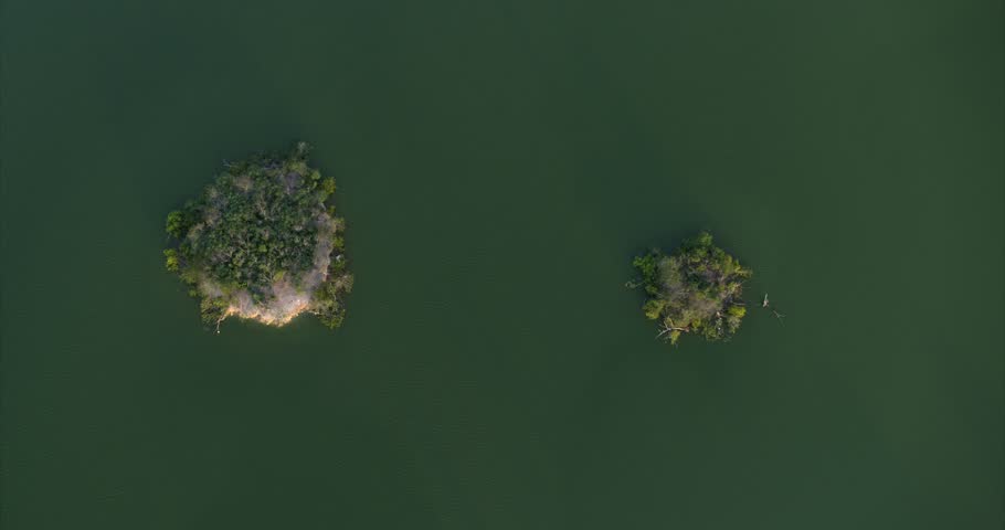 Descending Birds eye view of two small islands at Brays Bayou Park in West Houston, Texas