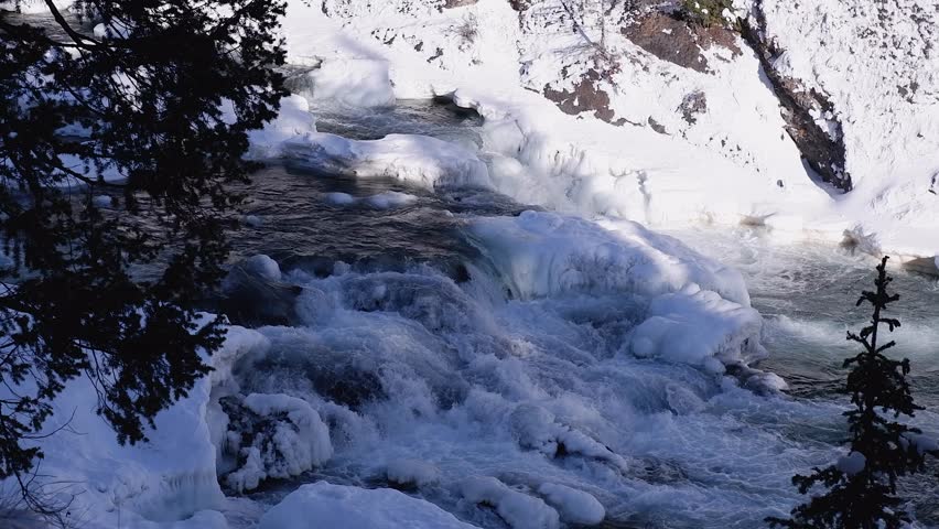 Ice on Bow Falls waterfall on river in Banff National Park, winter day