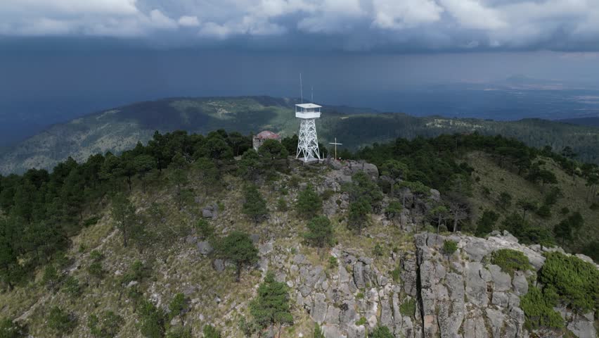 Aerial pulls out from lookout tower next to old hermitage on mtn top