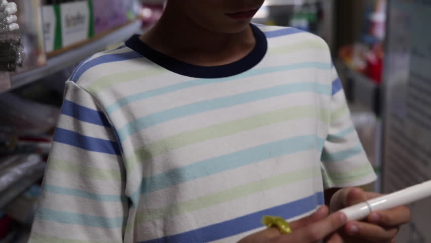 The boy smells a felt-tip pen, then makes a face. The art supplies shop