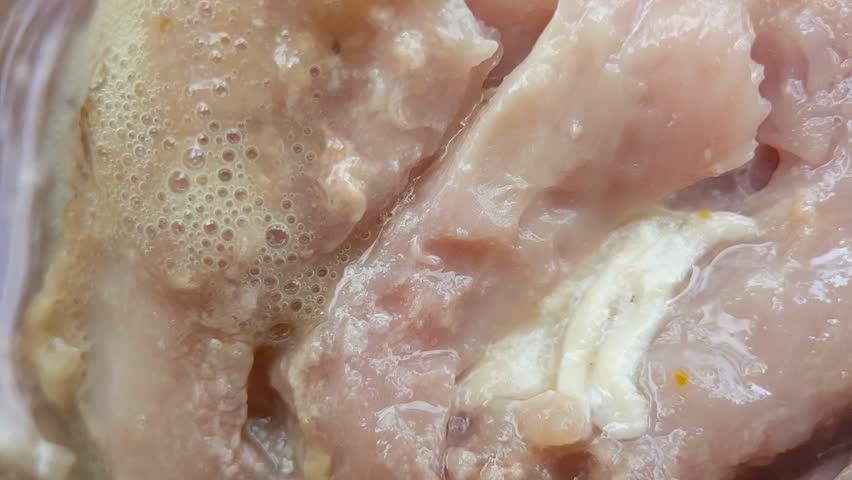 Macro of white maggots in dirty watery food. Dirty food waste that has been left for a long time will bring in garbage maggots. Handheld footage.