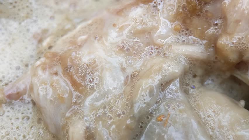 Macro of white maggots in dirty watery food. Dirty food waste that has been left for a long time will bring in garbage maggots. Handheld footage.