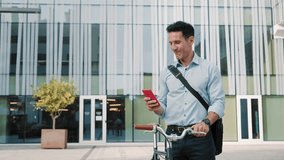 Businessman with bicycle using red cell phone app outside the office - Powered by Shutterstock - Get 15% off with code: PIKWIZARD15