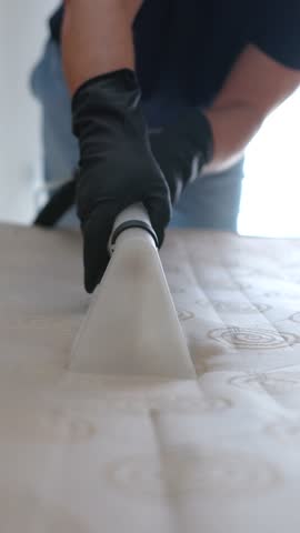 Chemical cleaning of mattress, cleaning mattress cover with vacuum cleaner, close-up, vertical video.