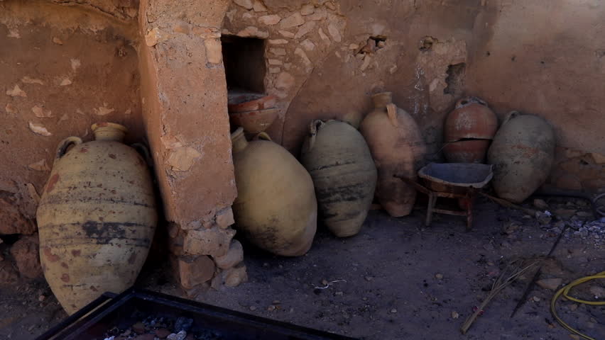 Ancient clay pots rest against a weathered wall in a traditional Tunisian ksar village