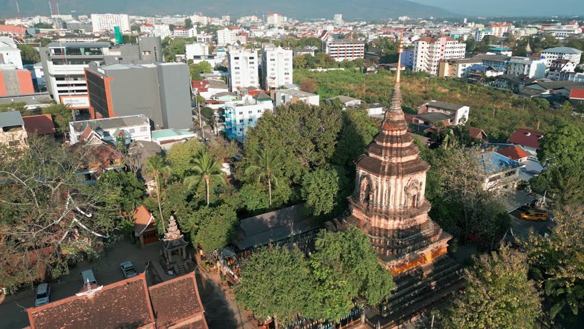Chedi Of Wat Lok Molee Temple With Cityscape In Background. Chiang Mai, Thailand. aerial arc shot
