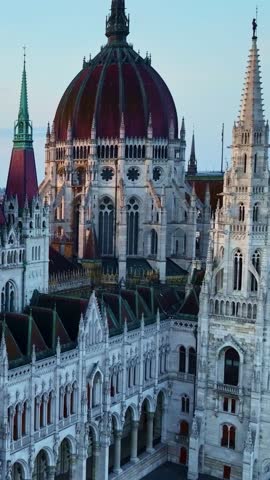Vertical drone view of parliament building in Budapest at sunrise, tourist attraction in Hungary, beautiful gothic architecture in Hungary capital. High quality 4k footage