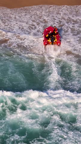 A slow motion drone vertical footage of a rescue boat crashing into the sand at Maroubra Beach, Sydney, New South Wales, Australia