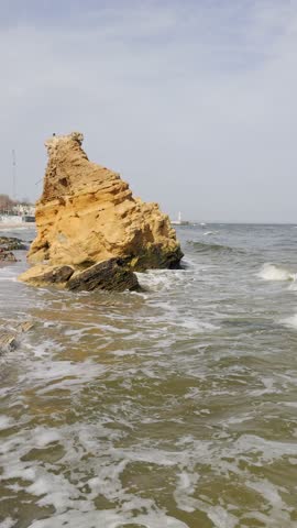 Dynamic pan scenery of waves splashing on big rocks on seashore of Odesa city, Ukraine