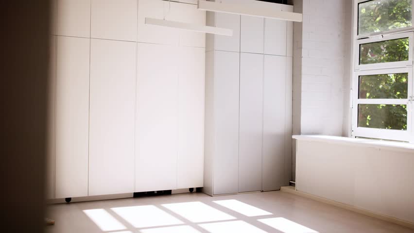 Young Hispanic designer showing luxury kitchen remodel to pregnant couple using air conditioner in real estate property with realtor.