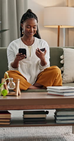 Happy woman, phone and credit card for online shopping in home by internet, web or app. African person, customer and smile for purchase, sale and successful payment by network, cellular or connection