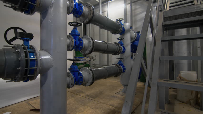 Pipework with valves to supply wastewater to tanks. Water head control system in workshop. Organization of equipment operation process