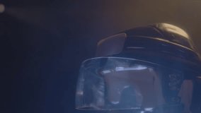 Modern protective hockey helmet in light smoke cloud on dark background closeup. Pathetic demonstration of team players equipment. Headgear item - Powered by Shutterstock - Get 15% off with code: PIKWIZARD15