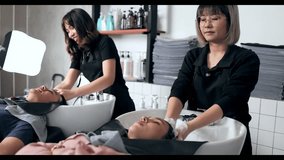Asian beauty salon employee is washing the hair of a customer in the hair salon - Powered by Shutterstock - Get 15% off with code: PIKWIZARD15
