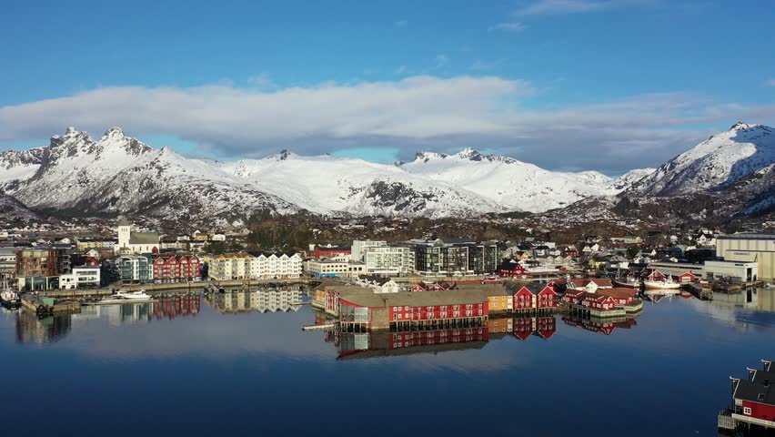 Winter Wonderland in a Norwegian Fjord: Snow-capped Mountains Reflect in the Calm Waters. A scenic view of a Norwegian fjord, where snow-covered mountains rise majestically in the background. 