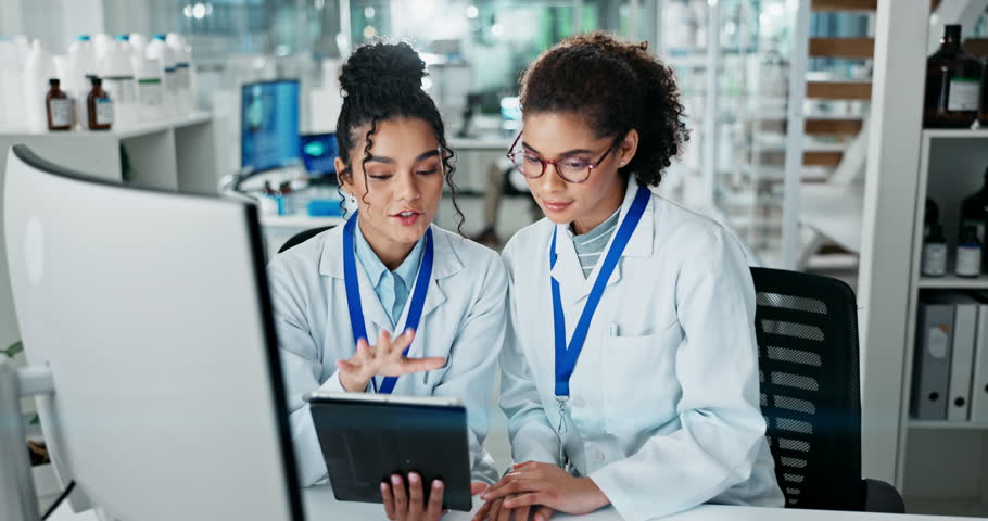 Women, scientist and happy at lab on computer for medical research with teamwork and collaboration. Employees, smile and conversation with online discovery for science, medicine and drug trial