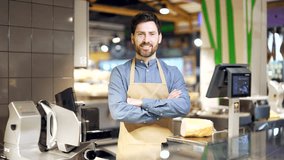 Portrait seller behind counter in grocery store. Meat department. Man in apron is the owner of a small business butcher shop smiles and looks at camera with arms crossed. Supermarket worker salesman - Powered by Shutterstock - Get 15% off with code: PIKWIZARD15