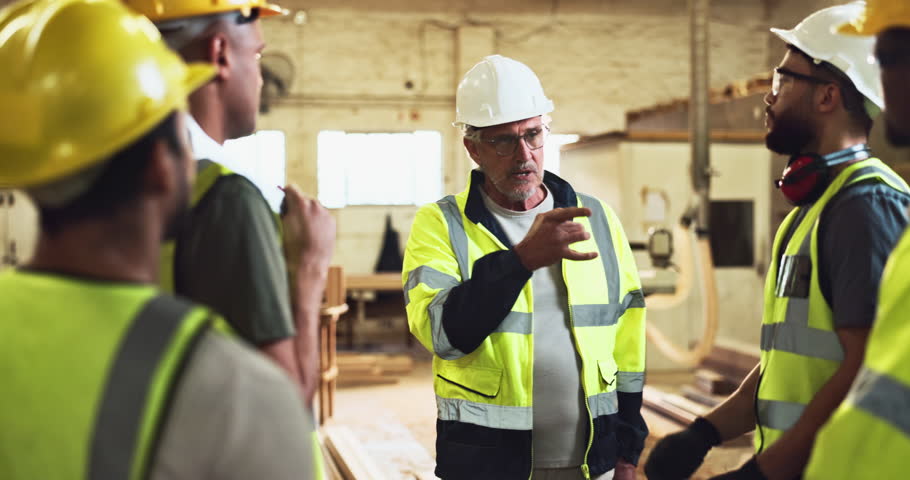 Construction team, briefing and safety instructions on site for compliance, maintenance and ppe by manager. People, planning and project meeting in building for progress, carpentry and communication