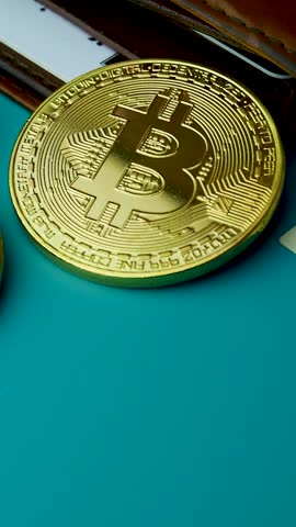 Gold Bitcoin BTC coins on bills of 100 dollars. Profit and wealth in virtual world. Virtual currency as safe-haven and hedge against inflation. Leather wallet with pockets for credit cards