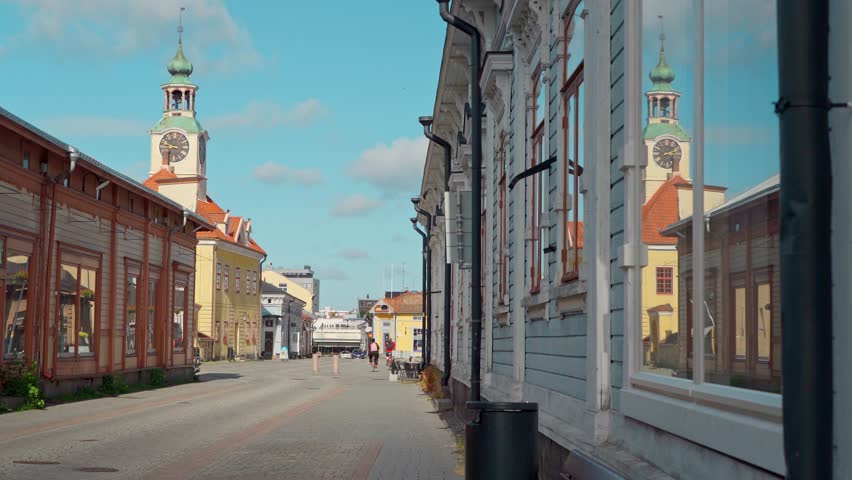 Rauma Street View With Clock Tower on Sunny Day	A street lined with buildings in Pori, Finland. The street is empty of people and traffic. The clock tower of a nearby building is visible in the dist