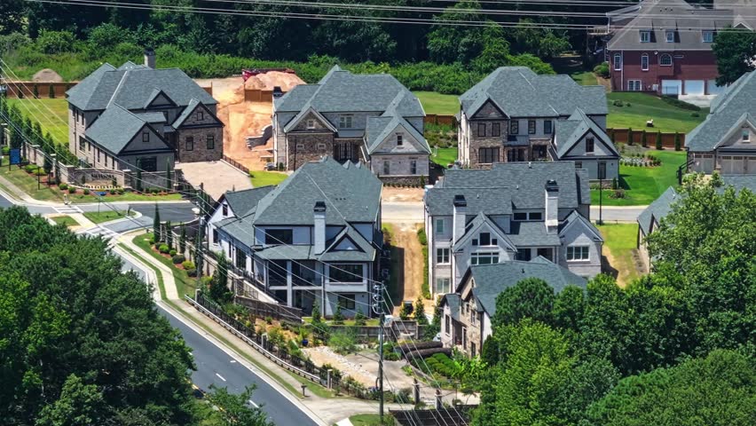 Large new developed Single Family homes in Suburb district of Marietta City, Georgia. Driving cars on road near forest. American style villas. Aerial zoom wide shot.