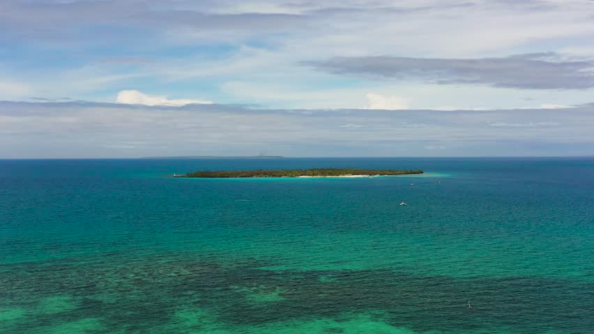 Virgin Island surrounded by blue sea and coral reefs. Blue sky and clouds. Bantayan, Cebu. Philippines.